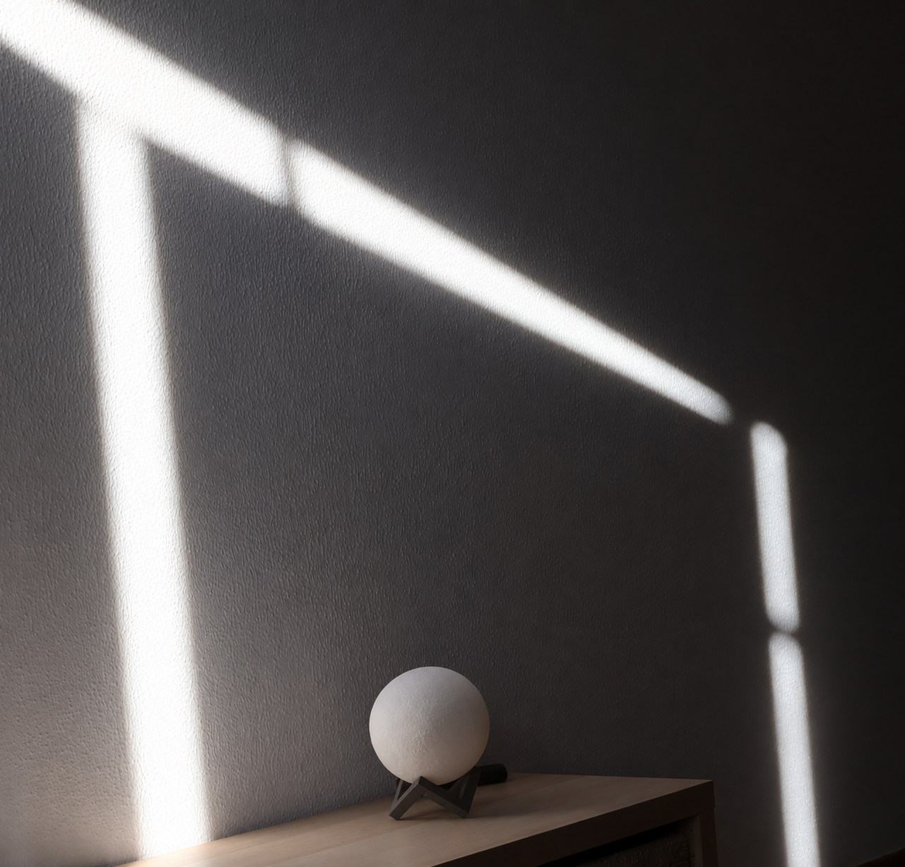 La luce del sole attraversa una parete in ombra, sopra una lampada sferica spenta