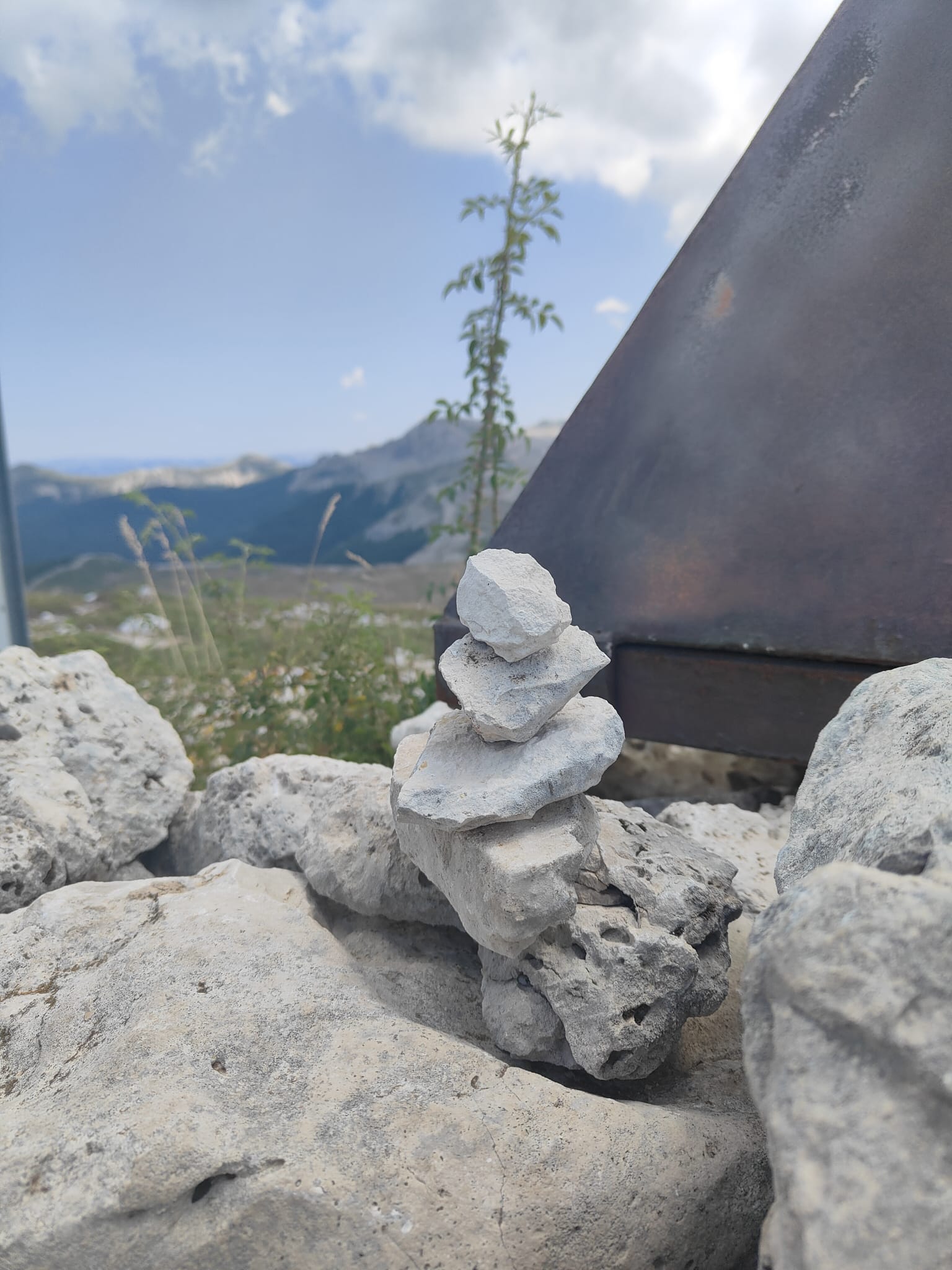 Una piccola torre di pietre in equilibrio, con le montagne sullo sfondo